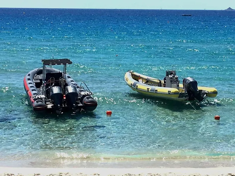 Deux bateaux semi-rigides amarrés dans une eau turquoise et claire