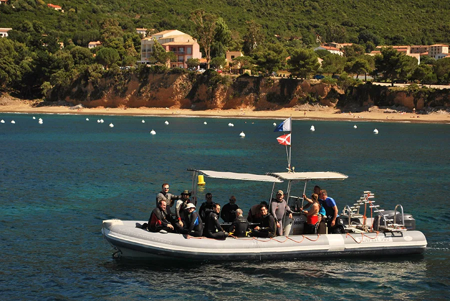 Groupe de plongeurs à bord d'un bateau semi-rigide en mer