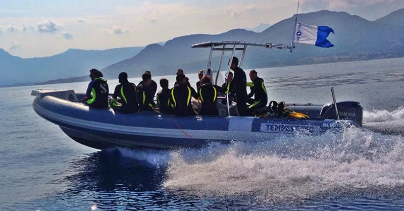 Groupe de plongeurs à bord d'un bateau semi-rigide en mer