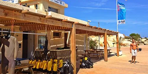Façade d'un centre de plongée avec bouteilles et un homme au soleil