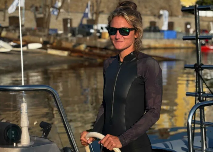 Femme souriante en combinaison de plongée sur un bateau au port