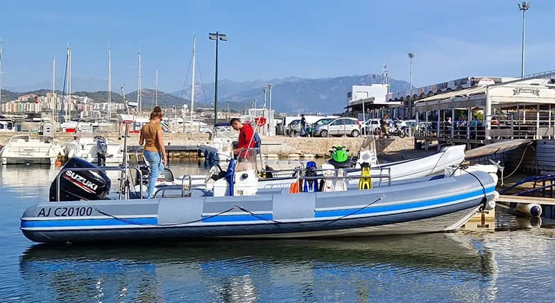 Bateau de plongée amarré dans un port avec des plongeurs et du matériel