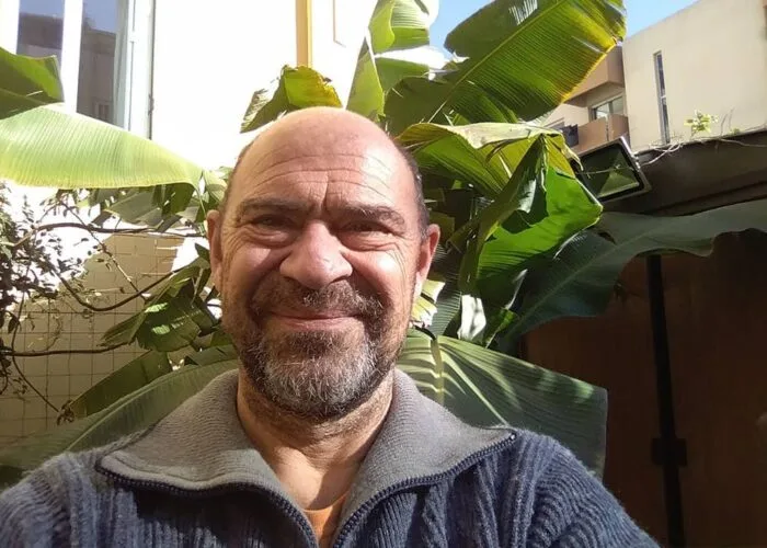 Portrait d'un homme souriant avec des plantes vertes en arrière-plan