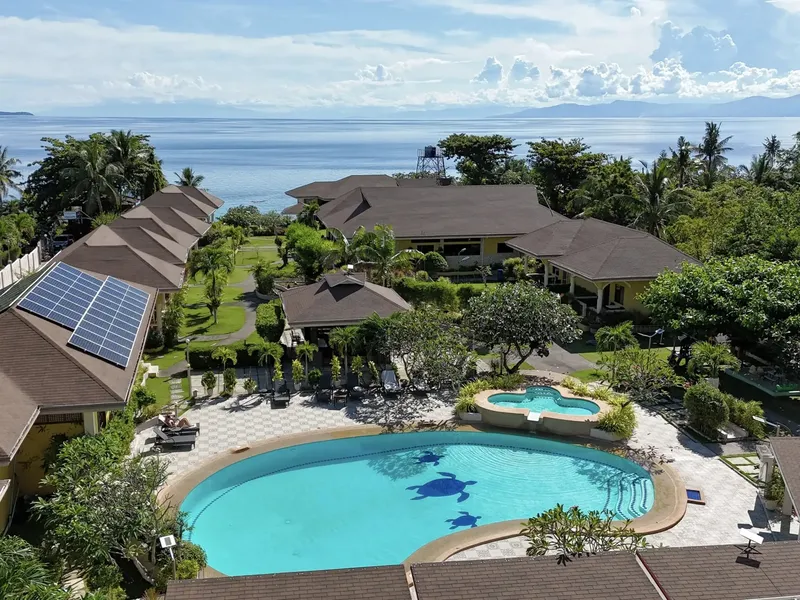 Vue aérienne d'un complexe hôtelier avec piscine et végétation tropicale
