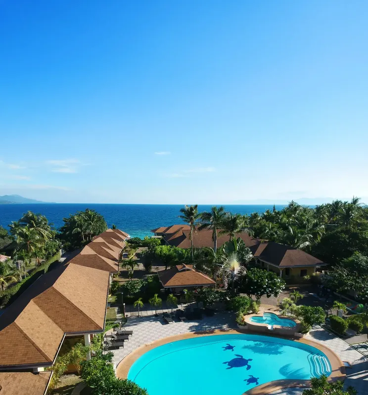 Vue aérienne d'un complexe hôtelier avec piscine et végétation tropicale