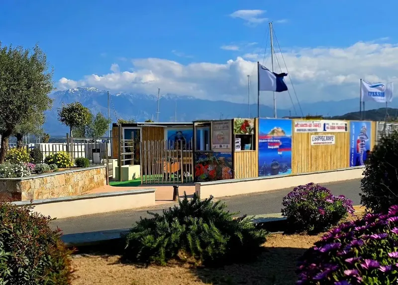Façade d'un centre de plongée avec des affiches et un drapeau bleu