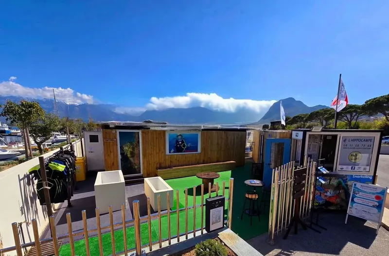 Devanture d'un centre de plongée avec matériel et vue sur la mer