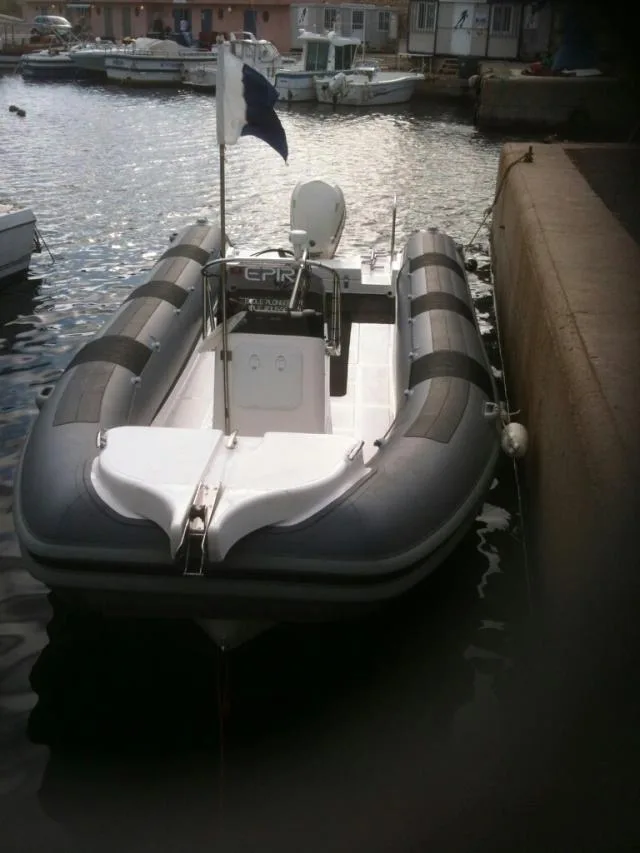 Bateau semi-rigide amarré dans un port ensoleillé avec des reflets