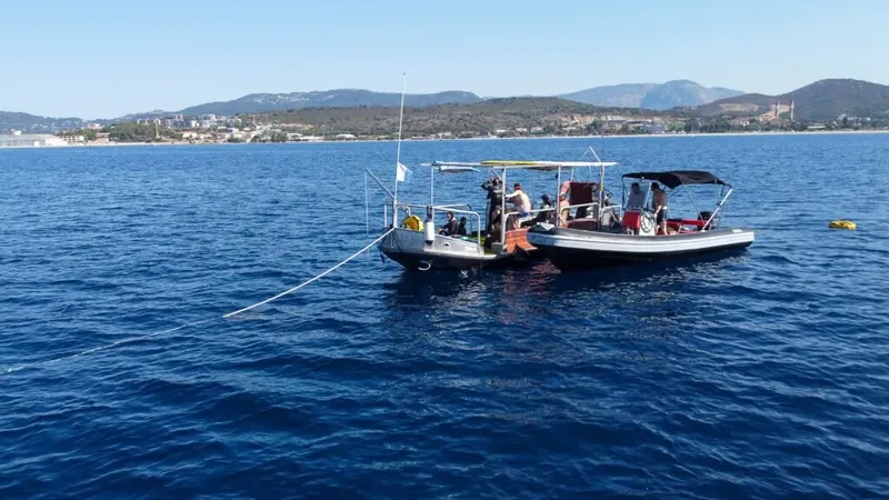 Bateau de plongée avec des passagers en mer, paysage côtier en arrière-plan