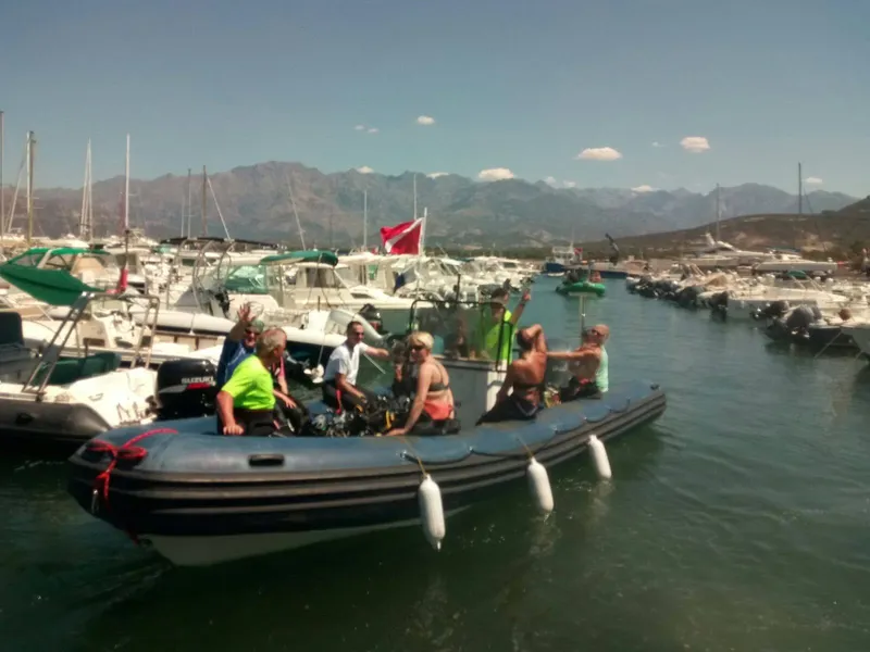 Groupe de personnes à bord d'un bateau semi-rigide dans un port