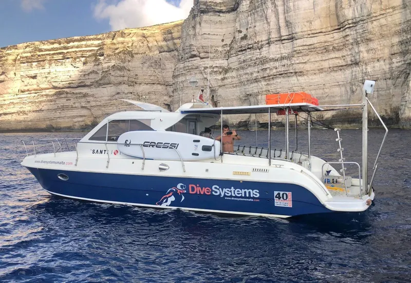 Bateau de plongée bleu et blanc avec des passagers en mer