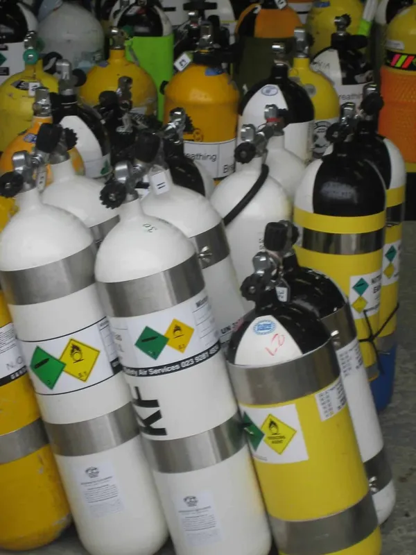 Bouteilles de plongée alignées avec étiquettes de gaz et numéros