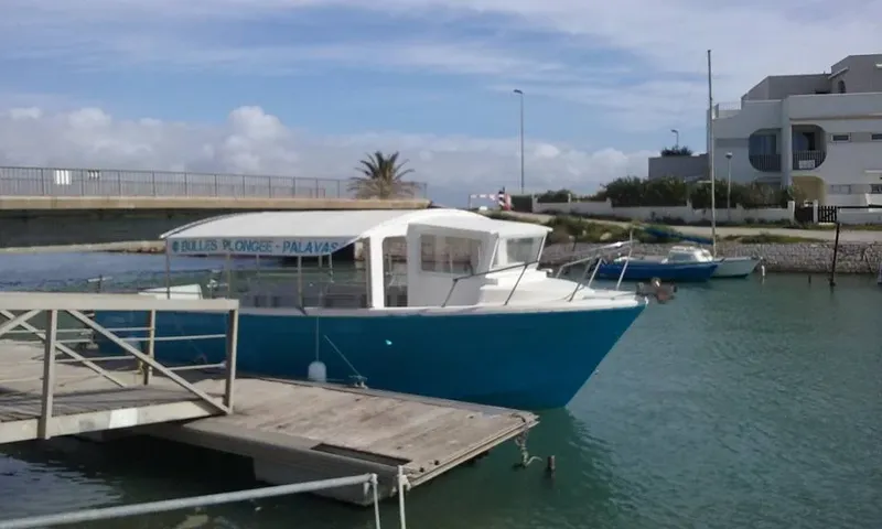 Bateau de plongée amarré à un ponton dans un port ensoleillé