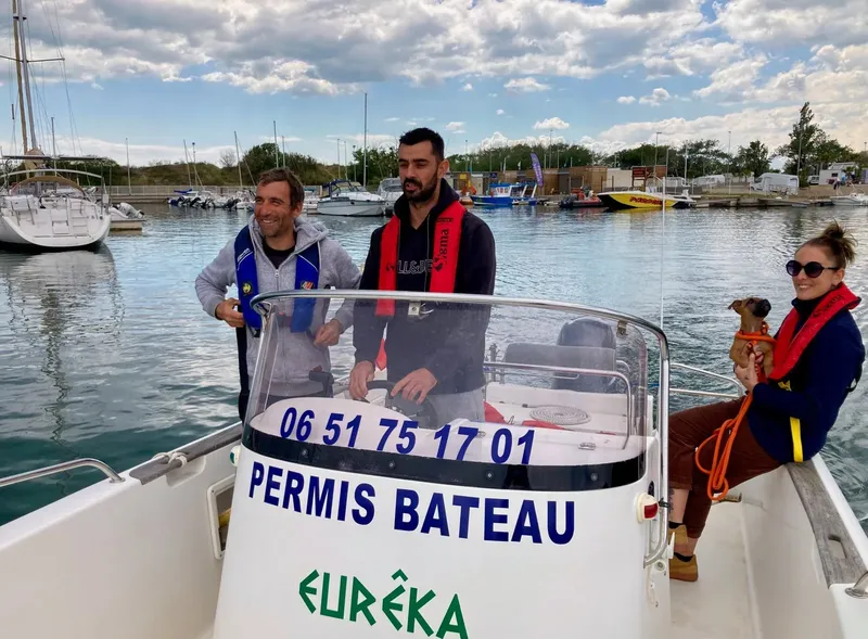 Quatre personnes souriantes sur un bateau avec inscription permis bateau