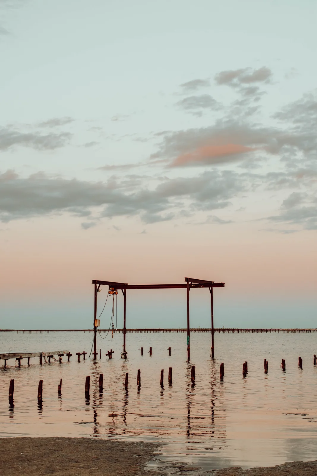 Structure en bois dans l'eau au lever ou coucher du soleil