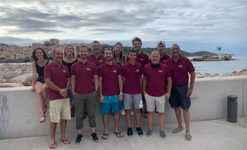 Groupe de personnes souriantes posant sur un quai ensoleillé