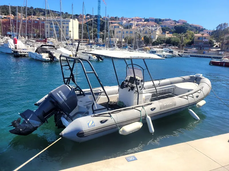 Bateau semi-rigide amarré dans un port ensoleillé avec d'autres bateaux