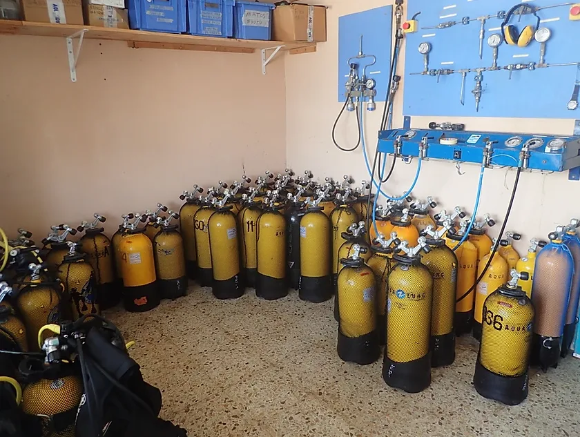 Rangées de bouteilles de plongée et de détendeurs dans un local