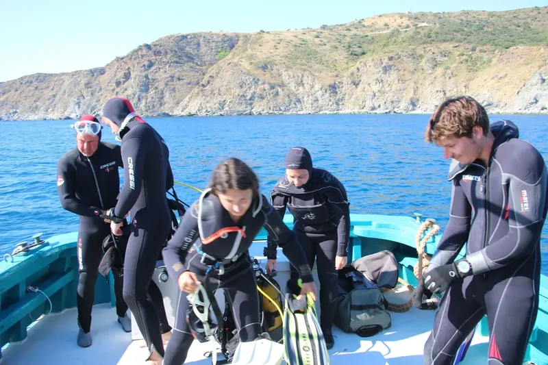 Plongeurs en combinaison se preparant a quitter un bateau de plongee