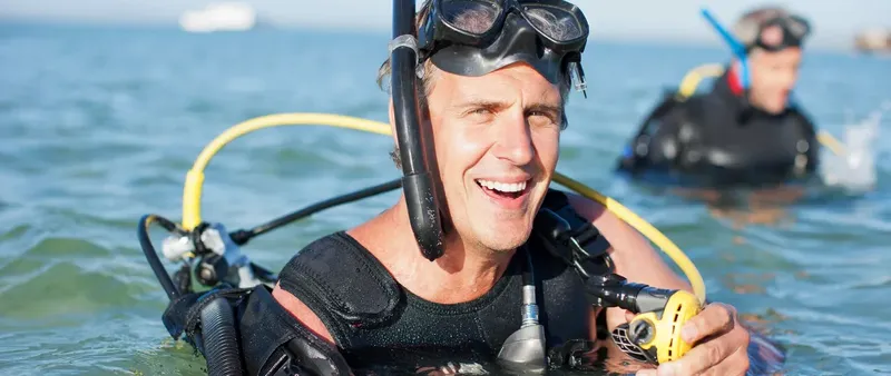 Plongeur souriant avec masque et tuba dans l'eau claire