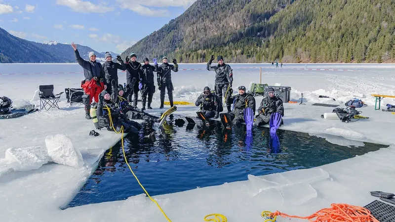 Groupe de plongeurs en combinaison sèche près d'un trou dans la glace