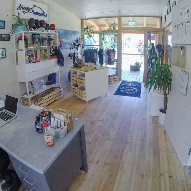 Intérieur d'un centre de plongée avec comptoir, étagères et équipements