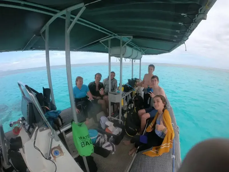 Groupe de personnes souriantes à bord d'un bateau de plongée