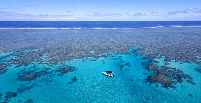 Vue aérienne d'un bateau de plongée au-dessus d'un récif corallien turquoise