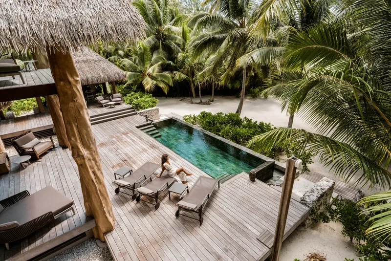 Vue aérienne d'une piscine et d'une terrasse avec une personne assise
