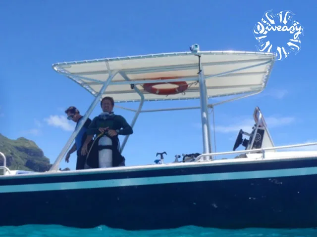 Plongeur s'équipant sur un bateau de plongée en mer turquoise