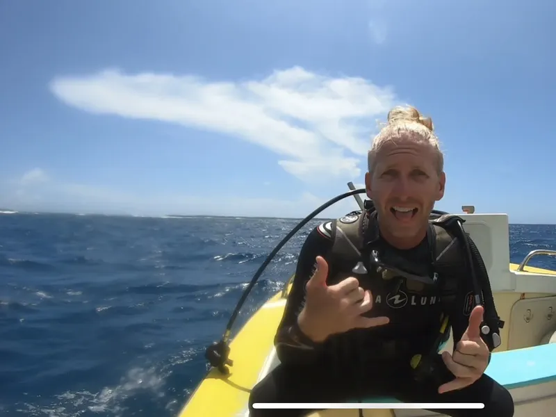 Plongeur souriant à bord d'un bateau jaune en pleine mer