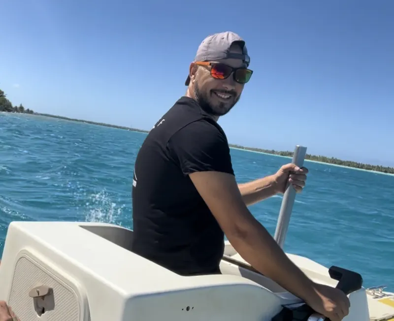 Homme souriant navigue sur un bateau rapide en mer turquoise