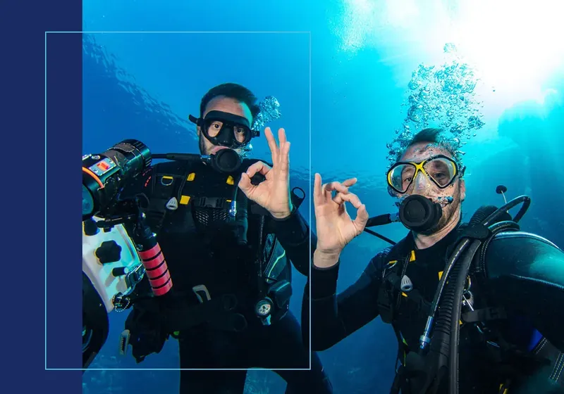 Deux plongeurs souriants font le signe OK sous l'eau