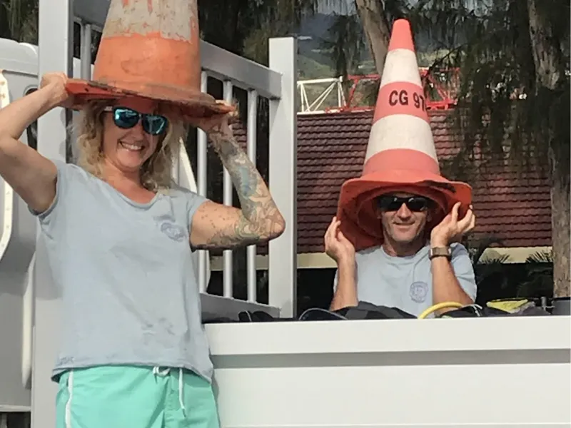 Deux personnes souriantes portant des cônes de signalisation comme chapeaux