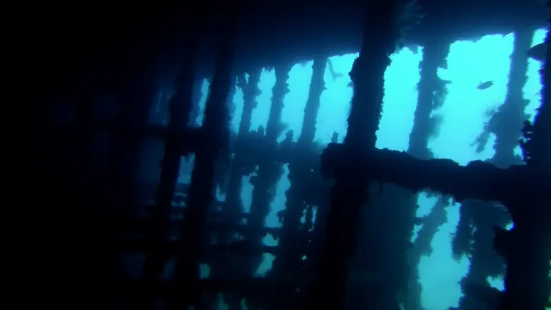 Structure métallique sombre sous l'eau avec lumière turquoise filtrant