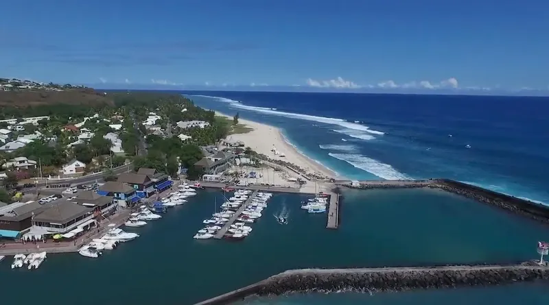 Vue aérienne d'un port de plaisance avec des bateaux amarrés et une plage