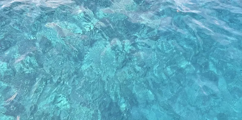 Vue aérienne de l'eau turquoise et des motifs sableux sous-marins