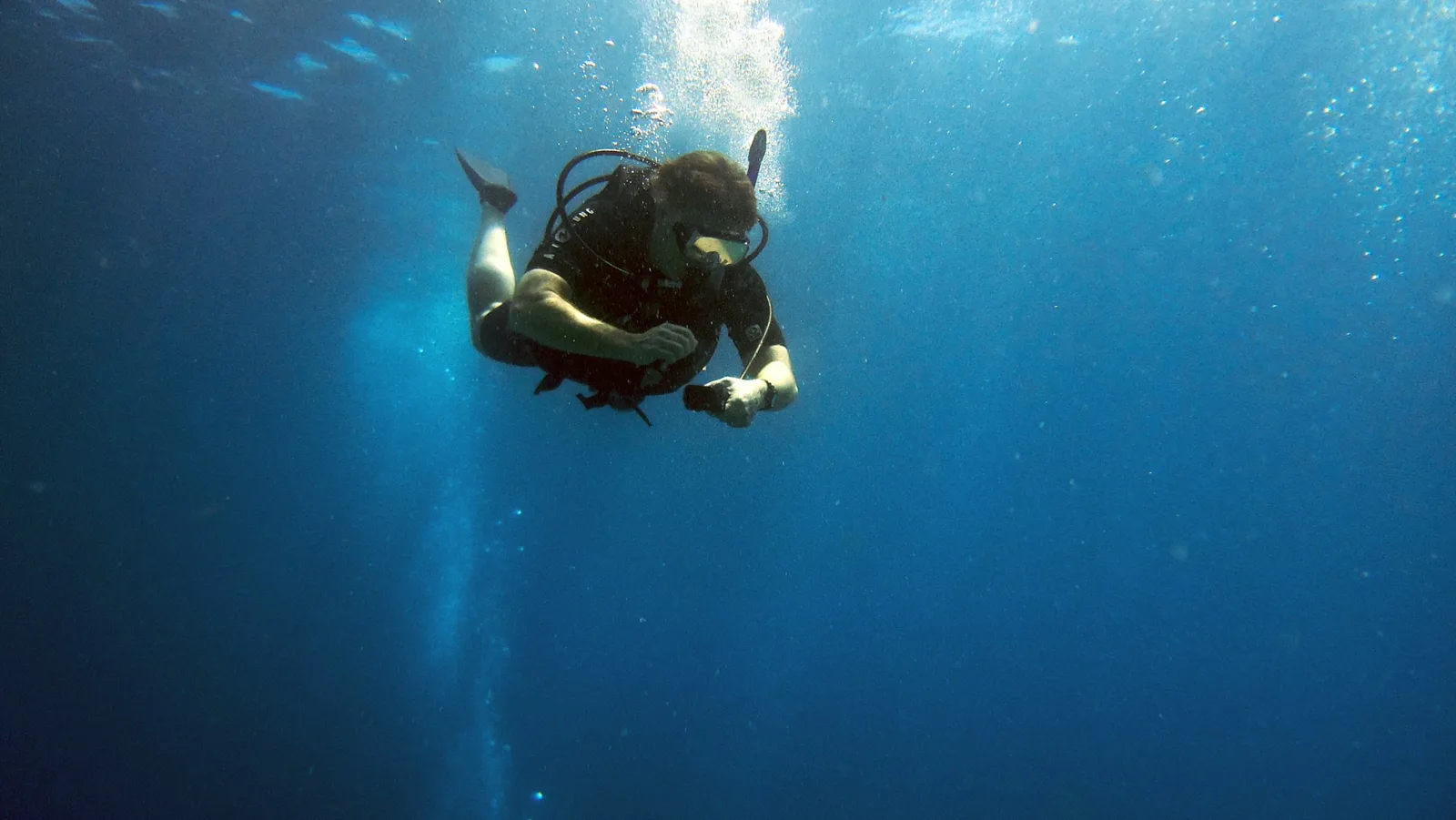 Plongeur en combinaison explore les profondeurs bleues de l'océan