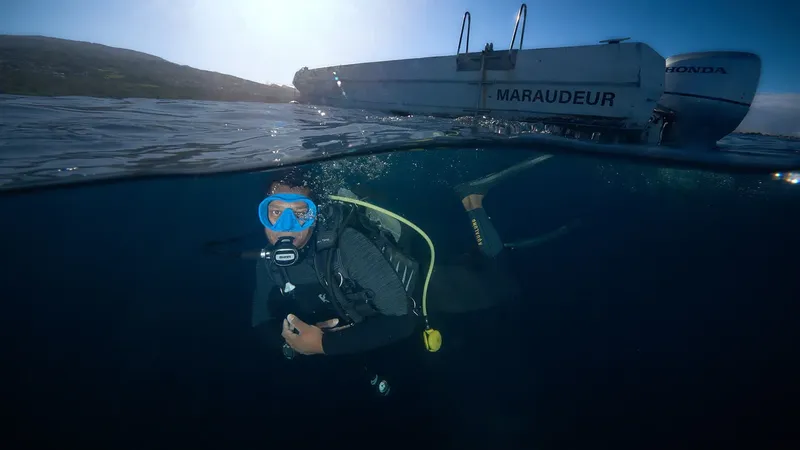 Plongeur regardant vers un bateau semi-rigide sur l'eau calme