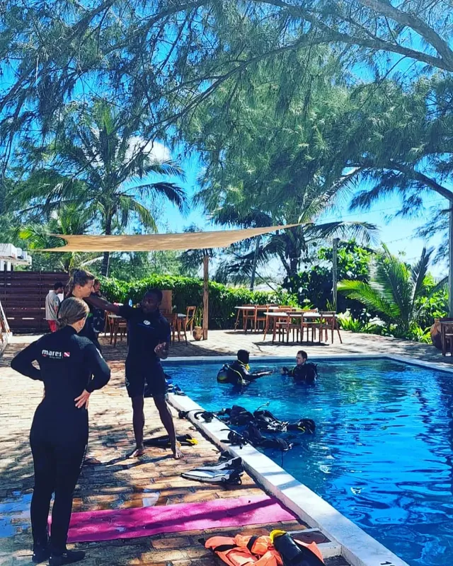 Personnes en combinaison de plongée près d'une piscine et du matériel