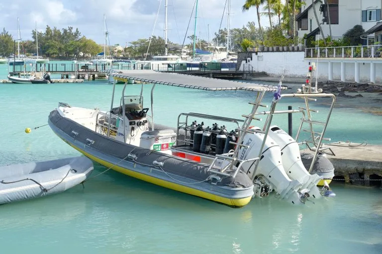 Bateau de plongée amarré au ponton avec des bouteilles à bord
