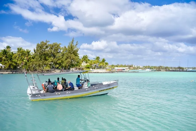 Bateau de plongée avec des passagers naviguant sur une eau turquoise