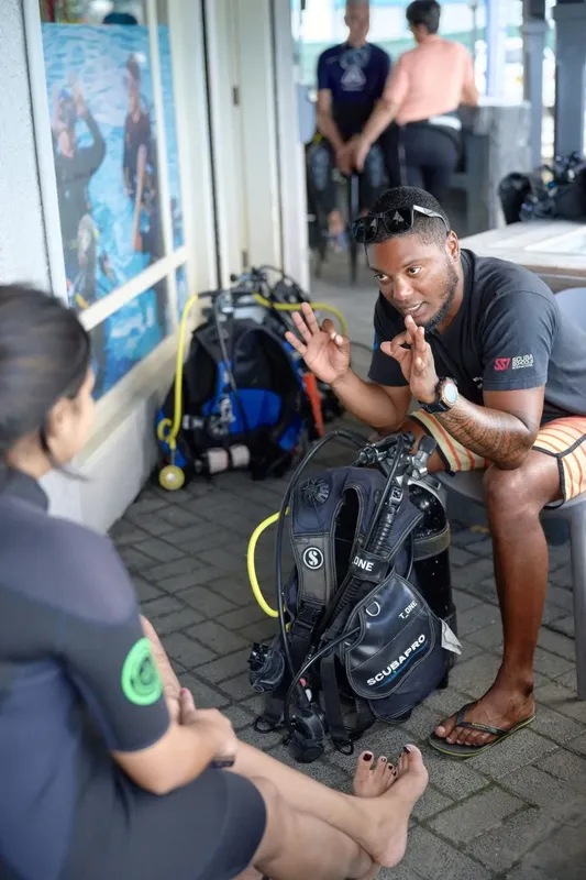 Un instructeur explique l'équipement de plongée à une élève attentive