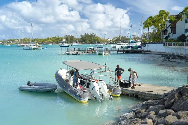 Préparation de plongée avec des bouteilles et un bateau semi-rigide