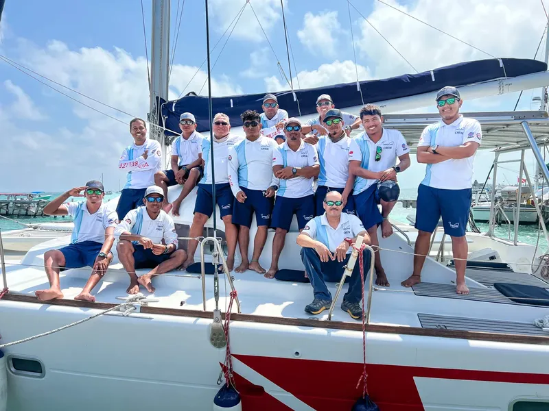 Groupe de personnes souriantes posant sur le pont d'un catamaran