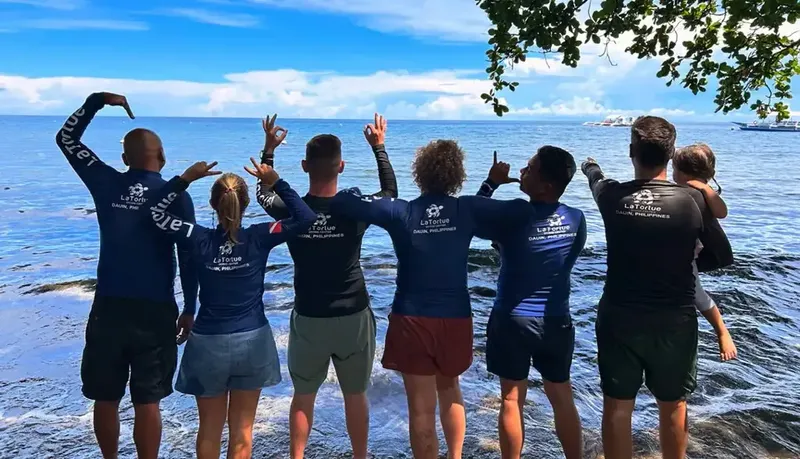 Groupe de personnes regardant la mer, sourires et gestes joyeux
