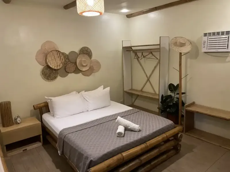 Chambre avec lit double, décoration en bambou et éclairage chaleureux