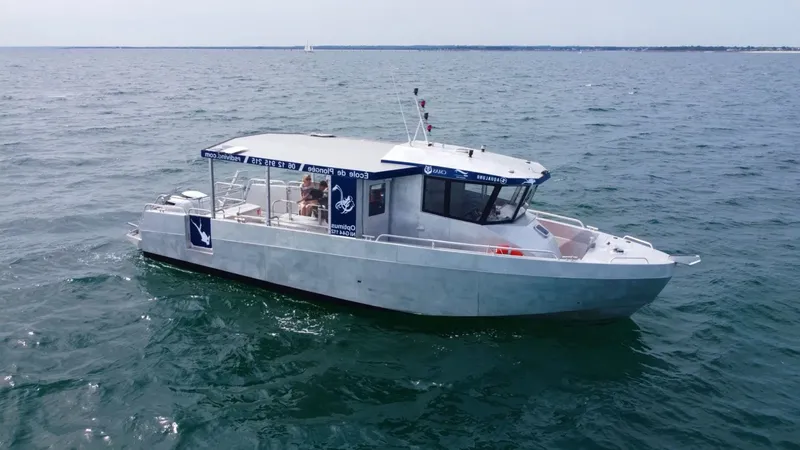 Bateau de plongée blanc navigue sur une mer bleue calme avec des passagers