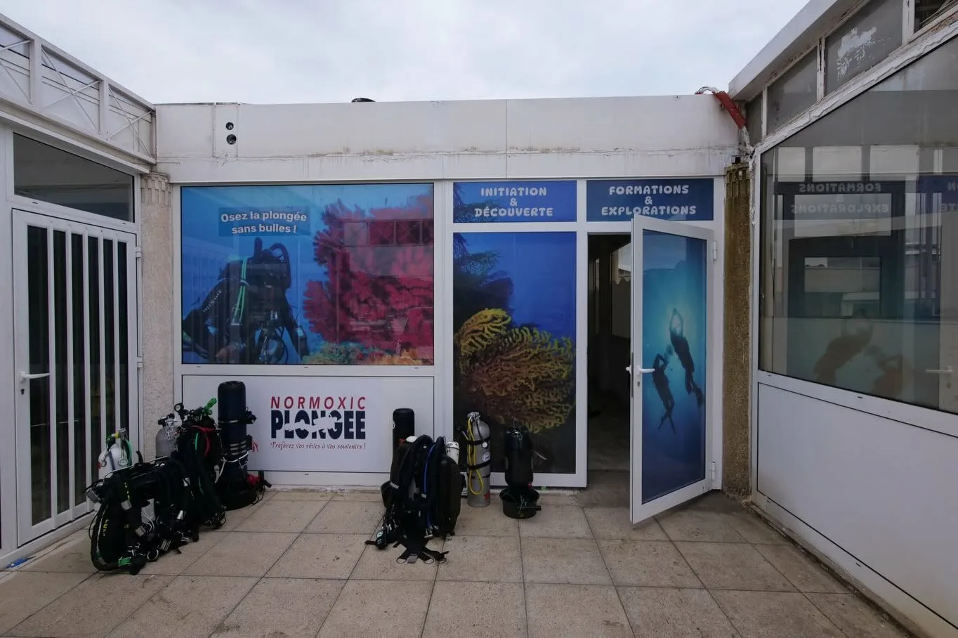 Devanture d'un centre de plongée avec affiches et équipements visibles