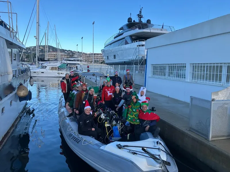 Groupe de personnes souriantes en tenues festives sur un bateau amarré